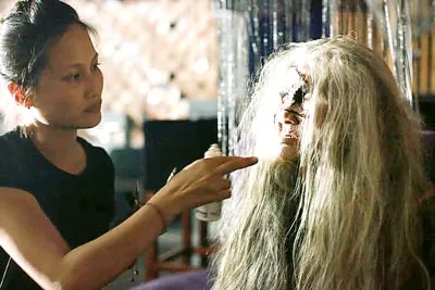 Lilian Trần đang hóa trang vai cụ già cho một diễn viên. Lilian Trần đang hóa trang vai cụ già cho một diễn viên.