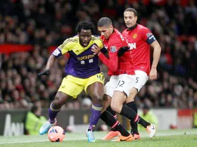 Tiền đạo Wilfried Bony (trái, Swansea) đi bóng trước hậu vệ Chris Smalling của Man.United. Tiền đạo Wilfried Bony (trái, Swansea) đi bóng trước hậu vệ Chris Smalling của Man.United.