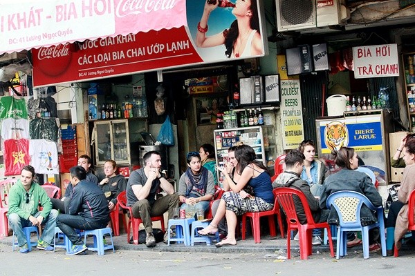 Foreigners drink bia hoi (Vietnamese fresh beer) in the Luong Ngoc Quyen street, Ha Noi. Korean tourists pose for a picture by the Hoan Kiem Lake.