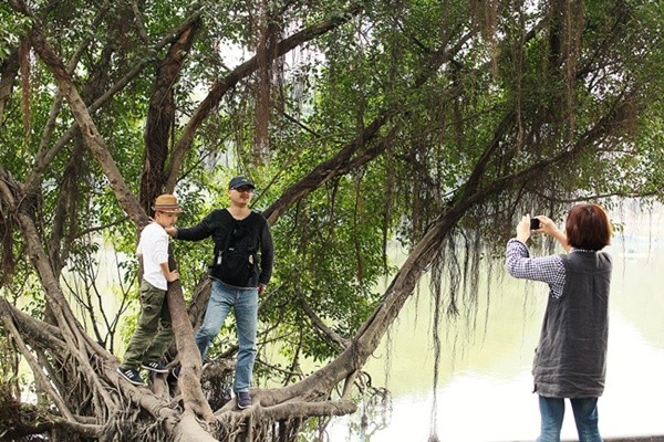 Korean tourists pose for a picture by the Hoan Kiem Lake.