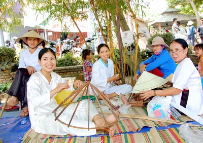 Knitting traditional non la (palm-leaf conical hat) of Vietnam at the ancient market of Thanh Toan Tile Bridge. (Photo: Sggp) Knitting traditional non la (palm-leaf conical hat) of Vietnam at the ancient market of Thanh Toan Tile Bridge. (Photo: Sggp)