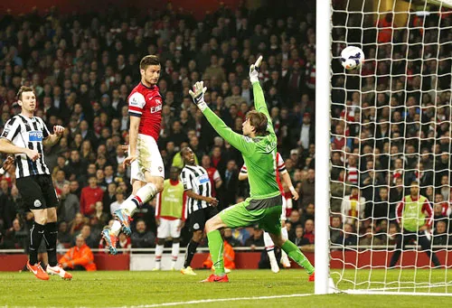 Tiền đạo Olivier Giroud (giữa) đánh đầu tung lưới thủ môn Tim Krul, ghi bàn ấn định chiến thắng 3 - 0 cho Arsenal. Tiền đạo Olivier Giroud (giữa) đánh đầu tung lưới thủ môn Tim Krul, ghi bàn ấn định chiến thắng 3 - 0 cho Arsenal.