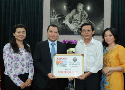 Nguyen MInh Tuan, Sai Gon Peninsula Corporation's director gives VND500 million to SGGP's Editor-in-Chief Nguyen Tan Phong (Photo: SGGP) Nguyen MInh Tuan, Sai Gon Peninsula Corporation's director gives VND500 million to SGGP's Editor-in-Chief Nguyen Tan Phong (Photo: SGGP)