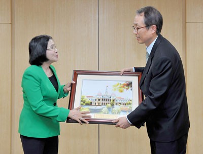 Nguyen Thi Thu Ha presents the South Korean Labor Relation Commission a picture of the HCMC People’s Committee office (Photo: SGGP) Nguyen Thi Thu Ha presents the South Korean Labor Relation Commission a picture of the HCMC People’s Committee office (Photo: SGGP)