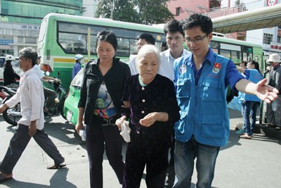 Young volunteers help a senior patient (Photo: SGGP)