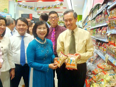 Deputy secretary of the HCMC Party Committee, Nguyen Thi Thu Ha (blue ao dai), and chief executive officer of NTUC FairPrice, Tan Kian Chew, at a Vietnamese goods stall in Singapore (Photo: SGGP) Deputy secretary of the HCMC Party Committee, Nguyen Thi Thu Ha (blue ao dai), and chief executive officer of NTUC FairPrice, Tan Kian Chew, at a Vietnamese goods stall in Singapore (Photo: SGGP)