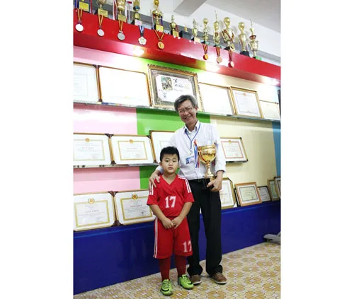 Thầy Hà Đức Lân, Phó Hiệu trưởng Trường Nguyễn Thượng Hiền, chụp hình cùng Messi nhí Hoàng Hiệp.