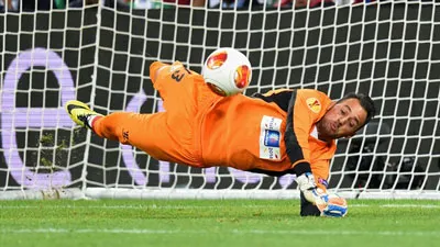 Thủ môn Beto (Sevilla) tung người cản phá cú sút phạt 11m của Rodrigo.