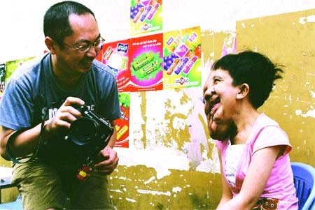 All smiles: Photojournalist Murayama Yasufumi chats with Do Thuy Duong, an Agent Orange victim, in HCM City in 2006. - VNS Photo Naohiro Yamada All smiles: Photojournalist Murayama Yasufumi chats with Do Thuy Duong, an Agent Orange victim, in HCM City in 2006. - VNS Photo Naohiro Yamada
