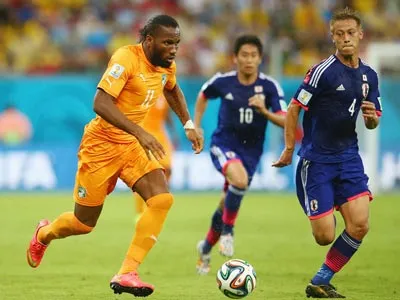 Tiền đạo Drogba (trái) tăng tốc trước Honda của Nhật Bản. Tiền đạo Drogba (trái) tăng tốc trước Honda của Nhật Bản.