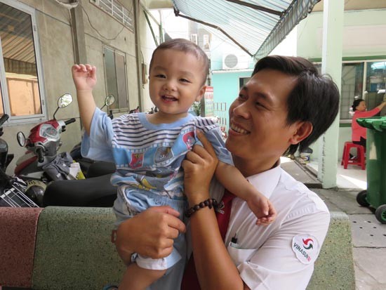 A fellow worker of driver Ho Minh Thuan holds the baby on the morning of December 2 (Photo: SGGP) A fellow worker of driver Ho Minh Thuan holds the baby on the morning of December 2 (Photo: SGGP)