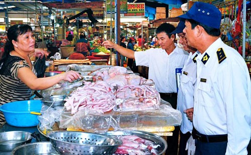 Inspectors examine meat at a market Inspectors examine meat at a market