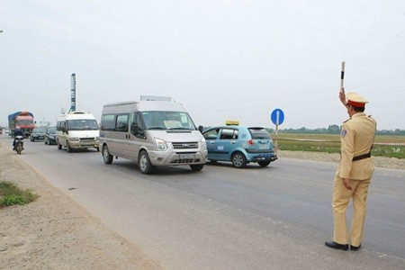 A traffic policeman stops an automobile in the northern province of Bac Giang. Transport authorities nationwide have ordered 2,500 company cars off the road for a month due to traffic violations. (Photo: VNA/VNS) A traffic policeman stops an automobile in the northern province of Bac Giang. Transport authorities nationwide have ordered 2,500 company cars off the road for a month due to traffic violations. (Photo: VNA/VNS)