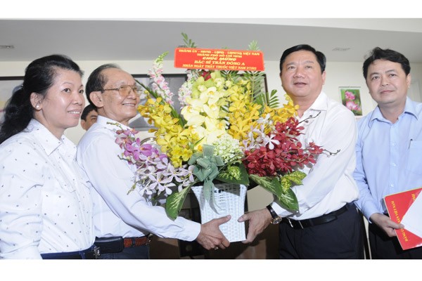 Secretary of the Ho Chi Minh City Party Committee Dinh La Thang (R) offers flowers to professor and doctor Tran Dong A on the occasion of Vietnam Doctor’s Day. (Photo: Sggp) Secretary of the Ho Chi Minh City Party Committee Dinh La Thang (R) offers flowers to professor and doctor Tran Dong A on the occasion of Vietnam Doctor’s Day. (Photo: Sggp)