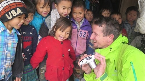 Making friends: Niggli shows pictures to ethnic children in Trạm Tấu District in Yên Bái Province. — Photo courtesy of World Vision.
