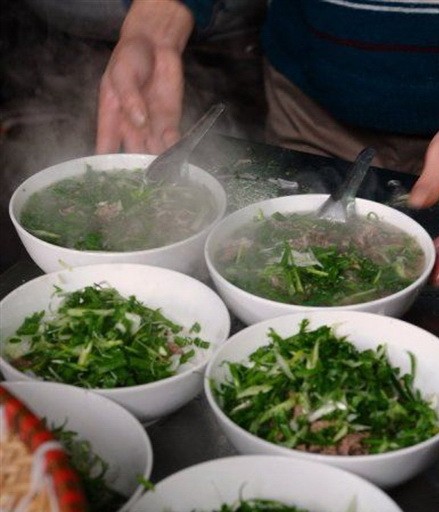 The broth at Phở Thìn is greasy and sweet, while the tái lăn is tender, mixed with ginger and garlic. VNS Photos Đoàn Tùng The broth at Phở Thìn is greasy and sweet, while the tái lăn is tender, mixed with ginger and garlic. VNS Photos Đoàn Tùng