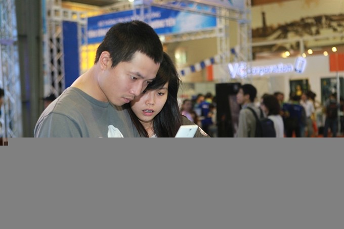 Customers use smartphones at an exhibition in Hà Nội. Smartphone subscriptions in Việt Nam are expected to triple from around 30 million in 2015 - VNS Photo Truong Vị Customers use smartphones at an exhibition in Hà Nội. Smartphone subscriptions in Việt Nam are expected to triple from around 30 million in 2015 - VNS Photo Truong Vị
