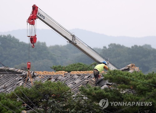 A construction worker replaces roof tiles on a house in Gyeongju, North Gyeongsang Province, on Sept. 22, 2016, after the city was damaged by an earthquake and aftershocks. (Yonhap) A construction worker replaces roof tiles on a house in Gyeongju, North Gyeongsang Province, on Sept. 22, 2016, after the city was damaged by an earthquake and aftershocks. (Yonhap)