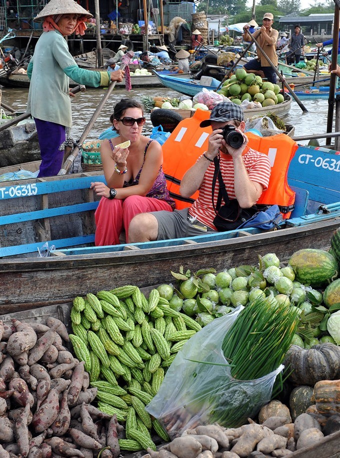 Foreign tourists visit Phong Điền floating market, a unique feature in local life, of Cửu Long (Mekong) Delta province of Cần Thơ. (Photo: VNA/VNS) Foreign tourists visit Phong Điền floating market, a unique feature in local life, of Cửu Long (Mekong) Delta province of Cần Thơ. (Photo: VNA/VNS)