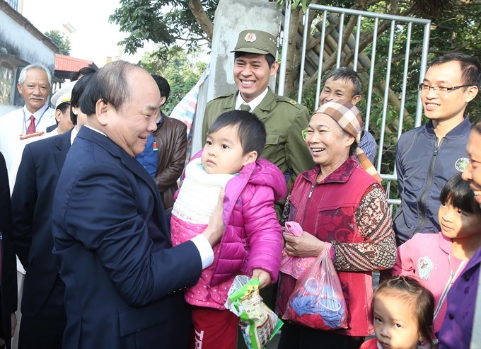 Prime Minister Nguyen Xuan Phuc (left) embraces a child during his visit to Hung Yen yesterday on the province’s 185th founding anniversary.