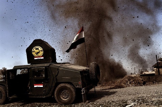 An explosion hits near a vehicle belonging to Iraq’s elite Rapid Response Division on February 25, 2017, during the assault to retake the western half of Mosul, which is still occupied by Islamic State group jihadists. - AFP/VNA Photo An explosion hits near a vehicle belonging to Iraq’s elite Rapid Response Division on February 25, 2017, during the assault to retake the western half of Mosul, which is still occupied by Islamic State group jihadists. - AFP/VNA Photo