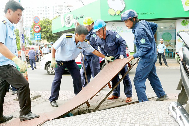 Workers remove a steel ramp from a pavement in District 1, HCMC (Photo: SGGP) Workers remove a steel ramp from a pavement in District 1, HCMC (Photo: SGGP)
