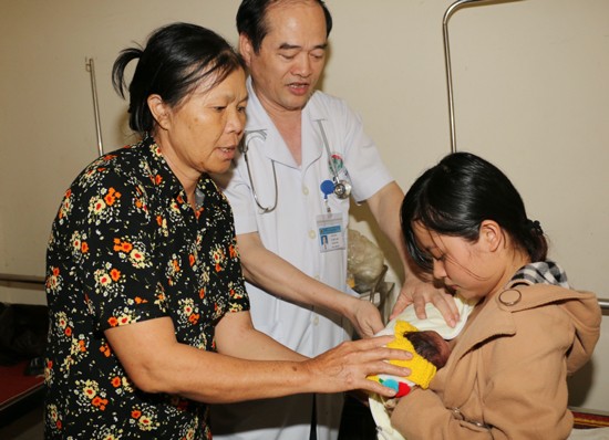 Dr. Le Huu Anh guides the mother how to warm premature baby(Photo: SGGP) Dr. Le Huu Anh guides the mother how to warm premature baby(Photo: SGGP)