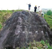 Historian Phillipe Le Failler (on top) and his Vietnamese assistants are studying the patterns on a rock.