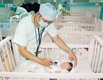 A doctor at SIHospital, a private hospital with high salary, examines a neonate A doctor at SIHospital, a private hospital with high salary, examines a neonate