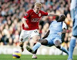 Tiền vệ Manchester United Paul Scholes (trái) sút bóng trước sự truy cản của hậu vệ Manchester City Hatem Trabelsi. Tiền vệ Manchester United Paul Scholes (trái) sút bóng trước sự truy cản của hậu vệ Manchester City Hatem Trabelsi.