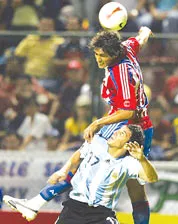 Santa Cruz (Paraguay) bật cao đánh đầu trước sự truy cản của Burdisso (17, Argentina). Santa Cruz (Paraguay) bật cao đánh đầu trước sự truy cản của Burdisso (17, Argentina).