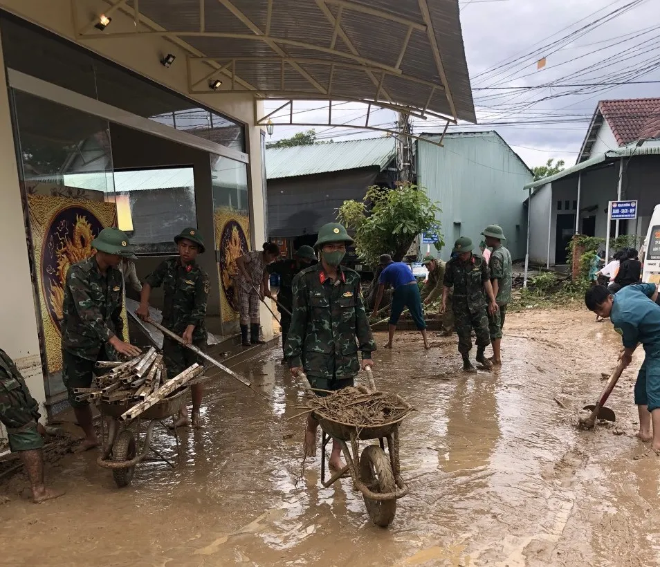 Chính quyền giúp dân dọn dẹp nhà cửa. Ảnh: VĂN NIỆM