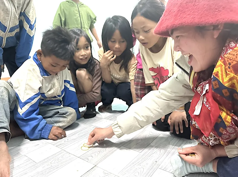 Giáo viên chơi với các em học sinh được đưa về trường nuôi dưỡng