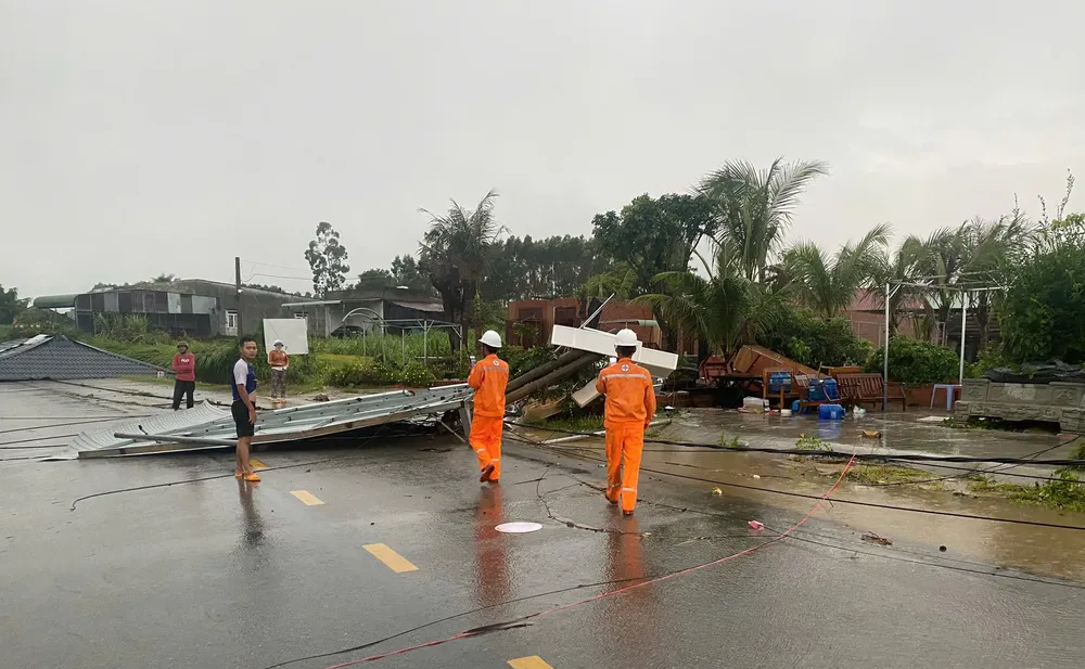 Nhân viên Điện lực Đăk Pơ hỗ trợ người dân khắc phục hệ thống dây điện. Ảnh: KP anh 2.jpg