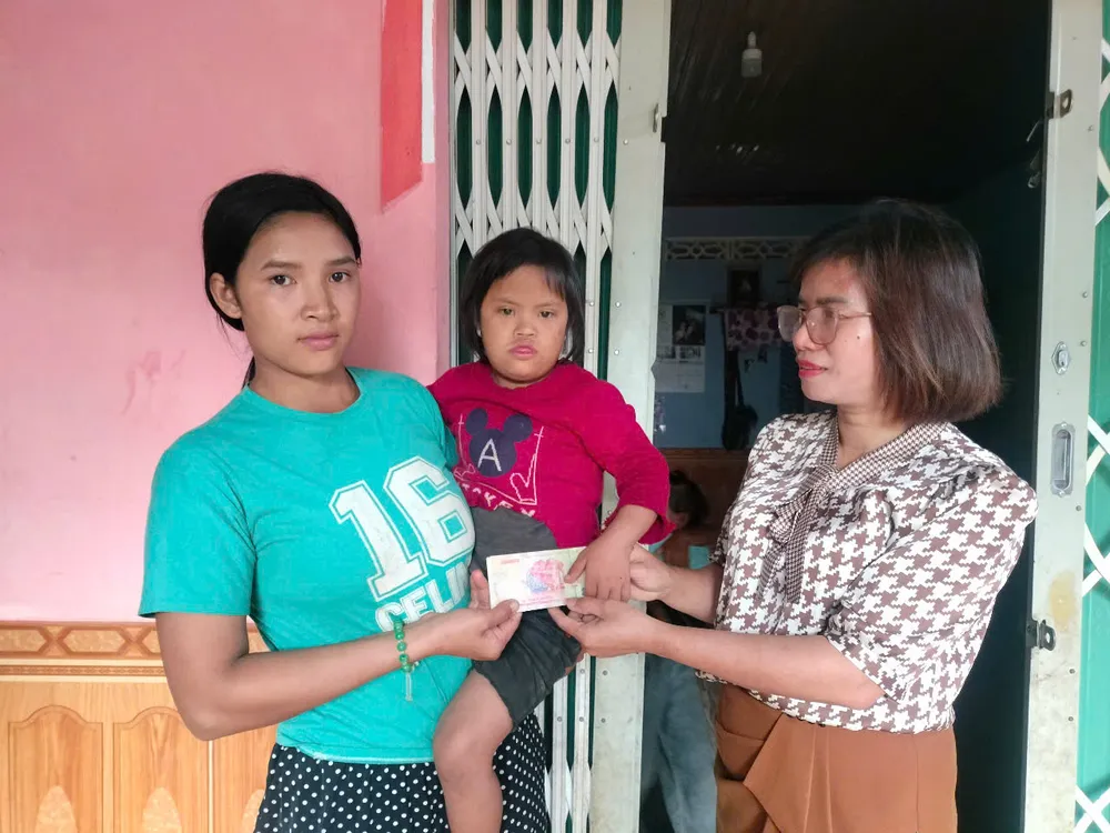 Bà Mai Thị Luận (bên phải, Phó Chủ tịch UBND xã Đăk Rơ Ông) thay mặt bạn đọc Báo SGGP trao tiền đến gia đình Y Lành fc998d69f28045de1c91.jpg