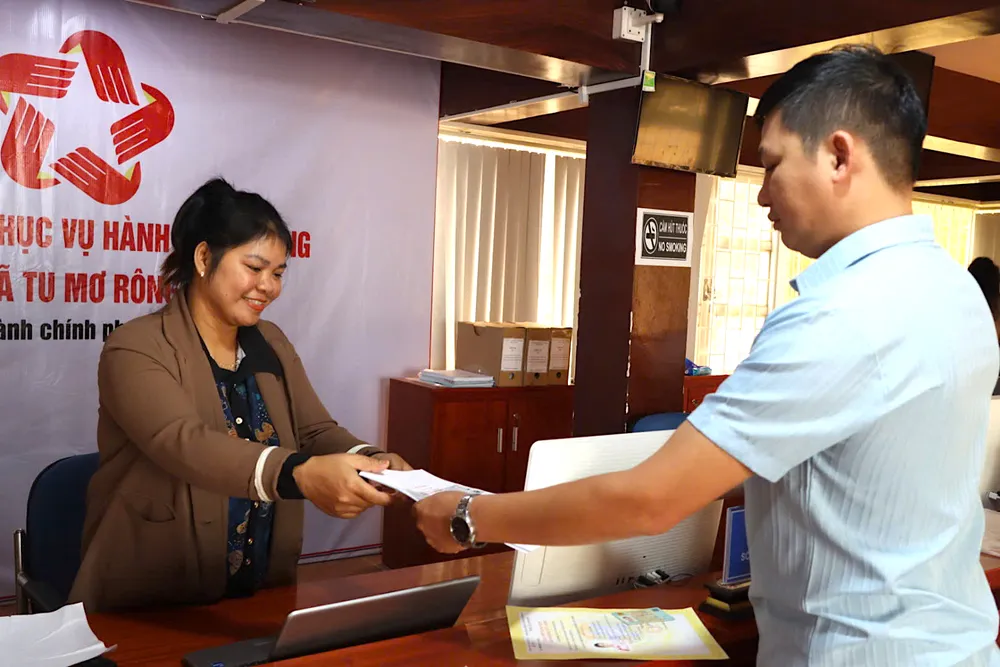 Cán bộ Trung tâm phục vụ hành chính công trao trả hồ sơ cho người dân đến làm thủ tục. Ảnh: HỮU PHÚC 01baa4faa55c12024b4d.jpg