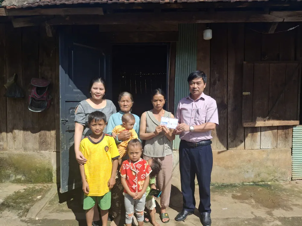 Ông Lê Hải Lâm, Chủ tịch UBND xã xốp (bên phải) thay mặt bạn đọc báo, trao tiền hỗ trợ đợt 2 đến gia đình anh A Tuất fcsd.jpeg