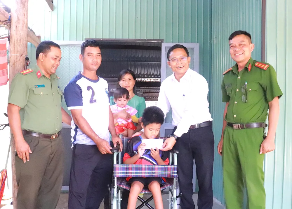Ông Phạm Văn Phương, Bí thư Đảng ủy xã Ia Hiao (áo trắng) cùng lãnh đạo Công an xã Ia Hiao trao tiền bạn đọc Báo SGGP hỗ trợ cho gia đình anh Nay Soan cred.jpeg