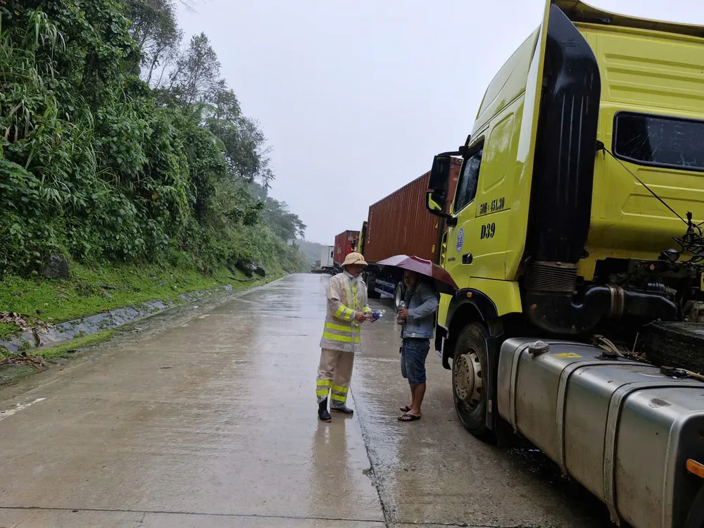 Het verkeerspolitiebureau van Ngoc Hoi voorziet bestuurders die op de pas wachten tot de aardverschuivingen zijn opgeruimd van water, voordat ze naar Da Nang rijden. vrgf.jpeg