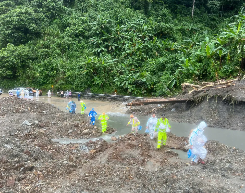 Lực lượng CSGT băng qua vị trí sạt lở để tiếp tế thực phẩm cho t ài xế bị mắc kẹt 0001.jpeg