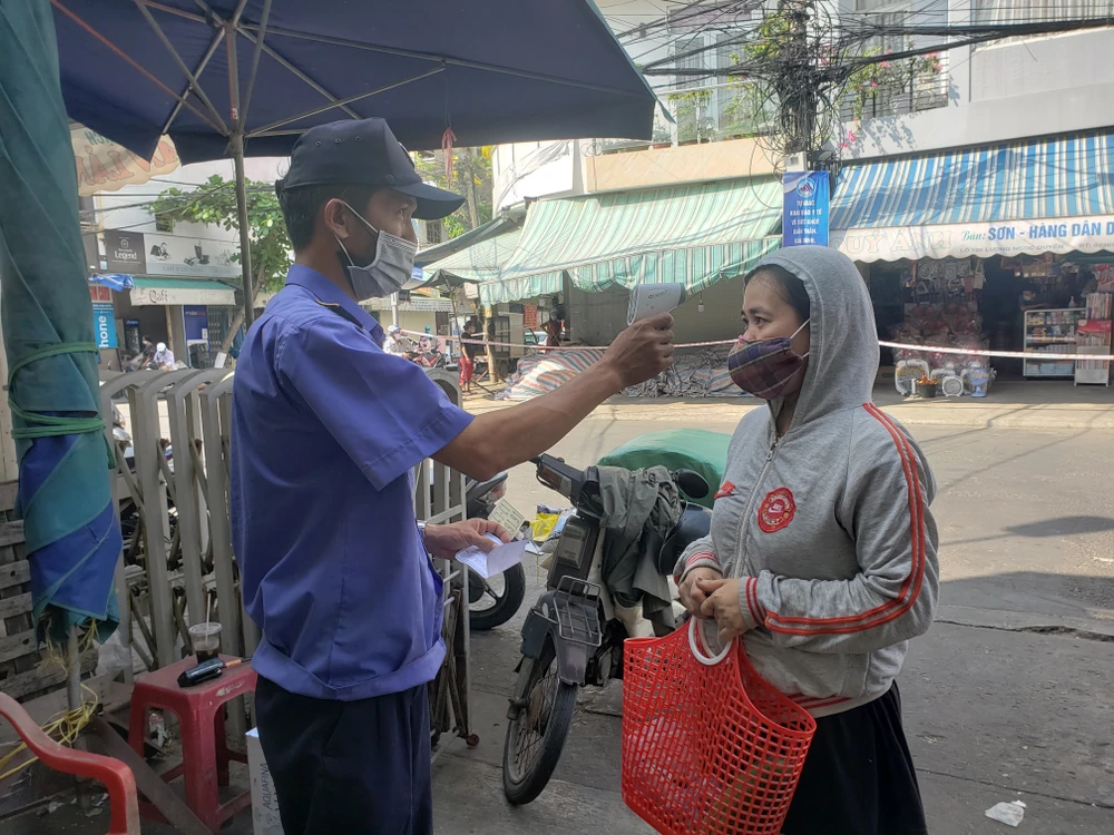 Từ 6 giờ sáng 9-5, Ban quản lý chợ Đống Đa bố trí 3 cổng vào chợ với đầy đủ lực lượng bảo vệ, triển khai yêu cầu người dân trình phiếu đi chợ, sát khuẩn và đeo khẩu trang trước khi vào