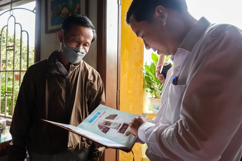 Ông Lê Phú Nguyện, Phó Chủ tịch UBND Hoàng Sa cùng gia đình nhân chứng Lê Châu (TP Hội An, tỉnh Quảng Nam) xem lại những tư liệu 