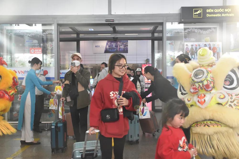 Du khách nội địa nhận quà tặng dịp đầu năm mới tại ga đến quốc nội. Ảnh: XUÂN QUỲNH Du khách nội địa nhận quà tặng dịp đầu năm mới tại ga đến quốc nội. Ảnh: XUÂN QUỲNH