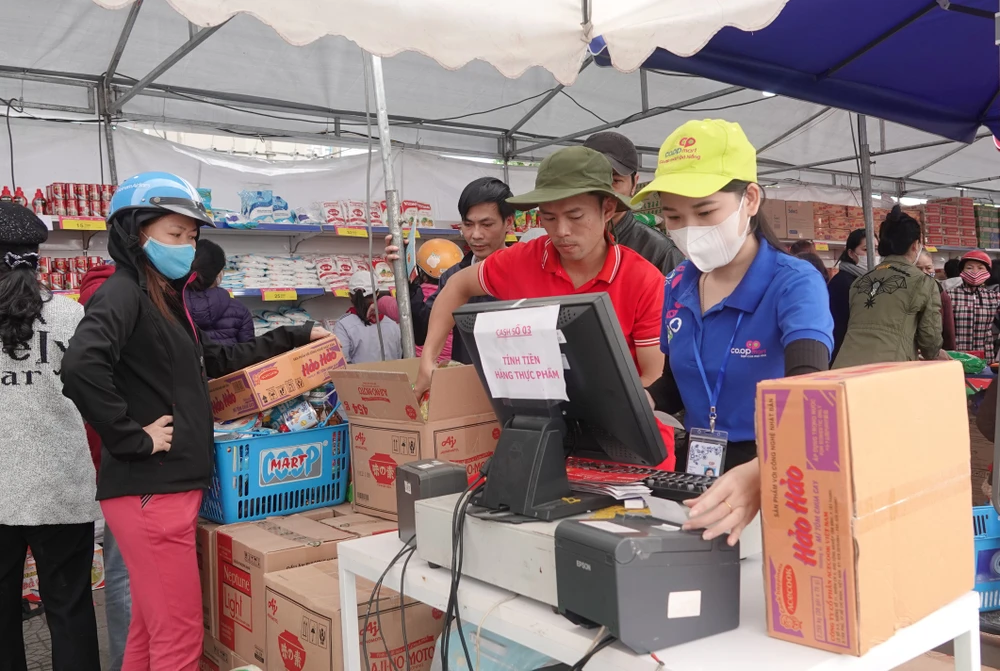 Mỗi hộ dân được trao tặng phiếu mua hàng có trị giá 1,000,000 đồng để mua hàng. Ảnh: XUÂN QUỲNH