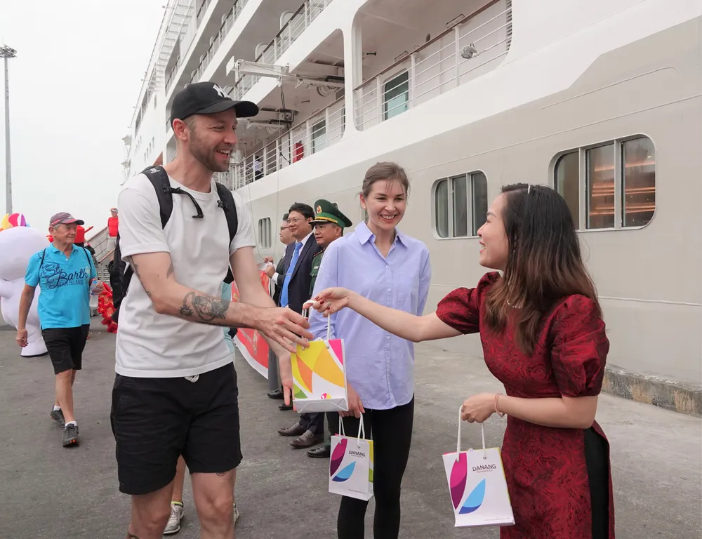 Tặng quà lưu niệm cho du khách quốc tế. Ảnh: XUÂN QUỲNH Tặng quà lưu niệm cho du khách quốc tế. Ảnh: XUÂN QUỲNH