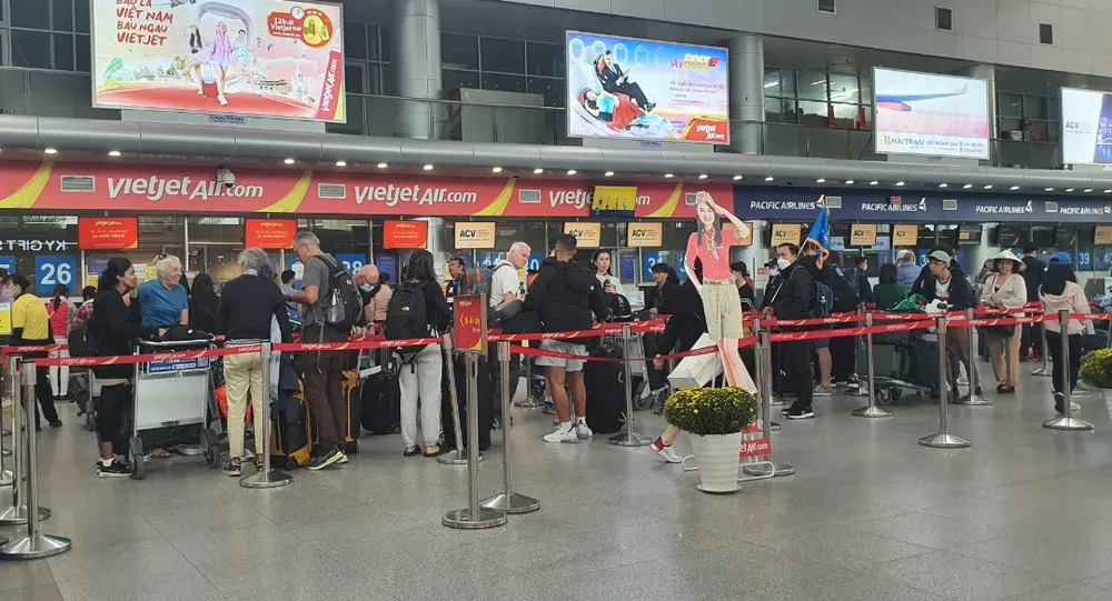 Hành khách phải xếp thành nhiều hàng để chờ đợi đến lượt làm thủ tục. Ảnh: XUÂN QUỲNH