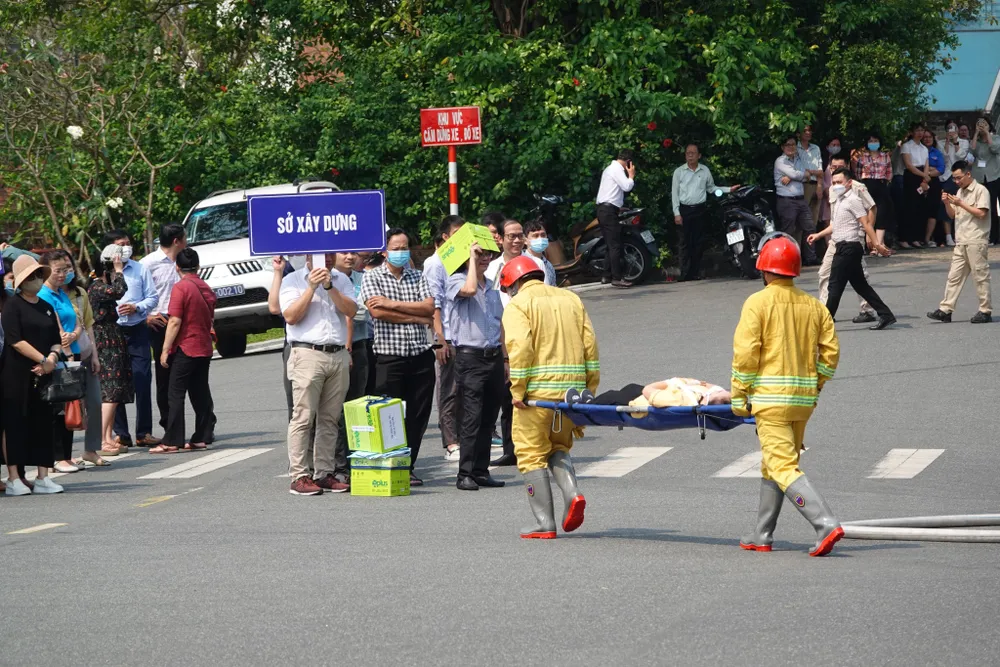 Hai chiến sĩ dùng cán đưa người bị thương không thể tự di chuyển đến xe cứu thương. Ảnh: XUÂN QUỲNH