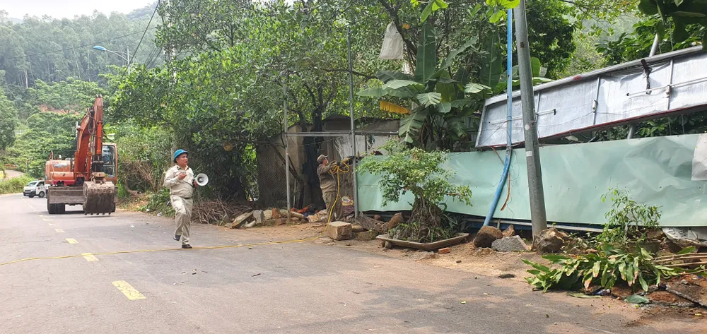 Lực lượng chức năng thông báo người dân không liên quan rời khỏi khu vực đang tiến hành cưỡng chế. Ảnh: XUÂN QUỲNH Lực lượng chức năng thông báo người dân không liên quan rời khỏi khu vực đang tiến hành cưỡng chế. Ảnh: XUÂN QUỲNH