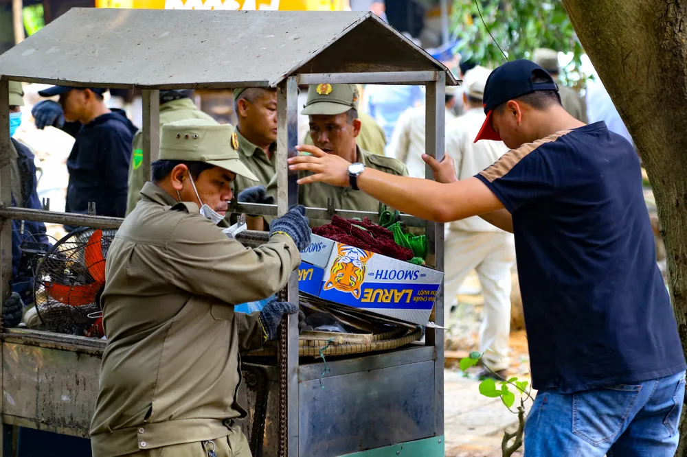 Lực lượng chức năng dọn dẹp các vật dụng được tháo dỡ. Ảnh: XUÂN QUỲNH Lực lượng chức năng dọn dẹp các vật dụng được tháo dỡ. Ảnh: XUÂN QUỲNH