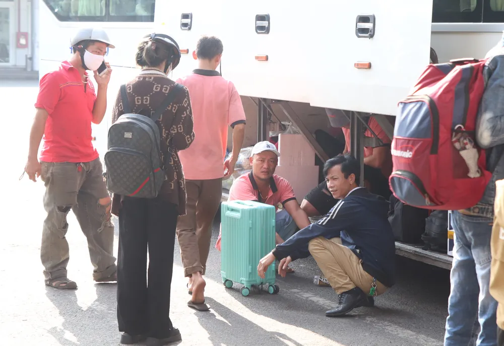 Nhiều người dân tay xách nách mang để về quê. Ảnh: XUÂN QUỲNH